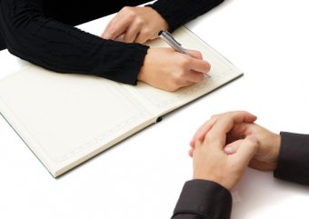 a man keeping notes while interviewing