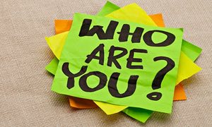 Who are you question - handwriting on a green sticky note